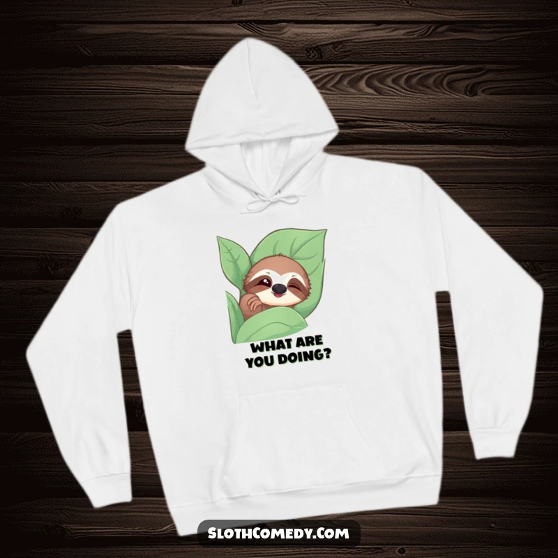 Funny hoodie featuring a sloth peeking from a leaf with a slow, curious blink, ideal for cozy humor.
