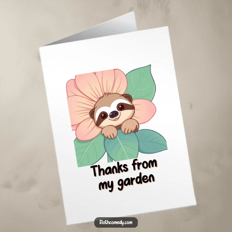 Free printable thank you card featuring a smiling sloth peeking from behind a large flower, offering thanks sweetly.